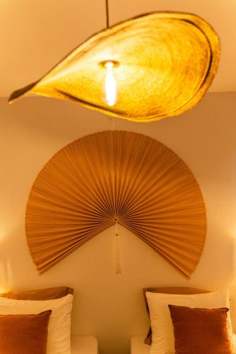 a ceiling light with a fan hanging over a bed at Villa Marinia 3*: Charme Créole in Saint-Denis