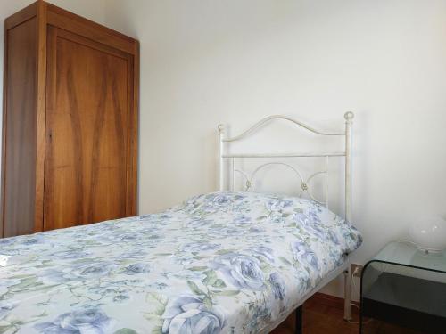 - une chambre dotée d'un lit avec une couette bleue aux motifs floraux dans l'établissement Appartamento Codroipo Centrale, à Codroipo