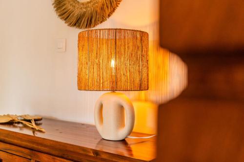 a table with a white vase with a lamp on it at Villa Marinia 3*: Charme Créole in Saint-Denis