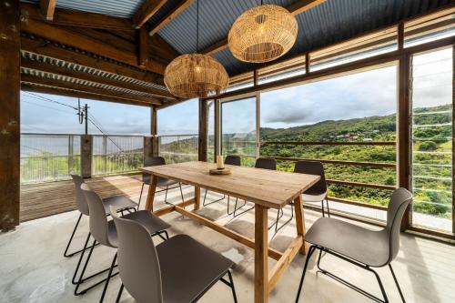 a dining room with a table and chairs and large windows at Villa Marinia 3*: Charme Créole in Saint-Denis
