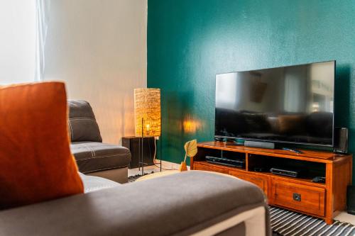a living room with a large flat screen tv at Villa Marinia 3*: Charme Créole in Saint-Denis