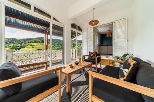 a living room with two couches and a large window at Villa Marinia 3*: Charme Créole in Saint-Denis