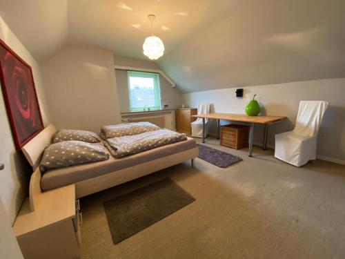 a bedroom with a bed and a table and a desk at Haus Ostend Ganzes Ferienhaus mit Garten ideal für zwei Erwachsene und zwei Kinder in Espelkamp
