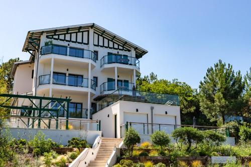 Großes weißes Gebäude mit Balkon in der Unterkunft Pyla Plage - appartement vue mer - Perle(o) in La Teste-de-Buch