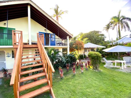 a house with a staircase in front of a yard at Arena Oceanview Hotel & La Terraza Restaurant in Las Galeras