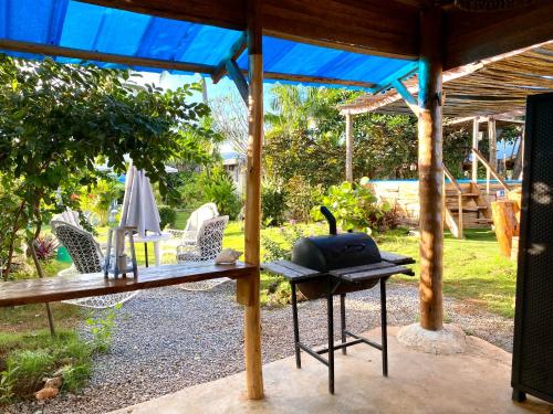 a table and chairs under a pavilion in a yard at Arena Oceanview Hotel & La Terraza Restaurant in Las Galeras