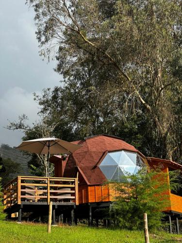 a house with an umbrella in a field at Glamping Shalom in Choachí
