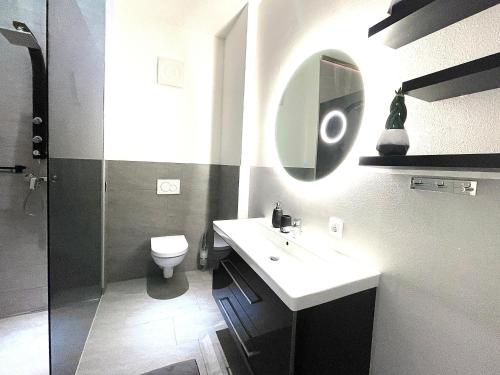 uma casa de banho com um lavatório, um WC e um espelho. em Alpenluxus' DESIGN LODGE with terrace & car park em Kramsach