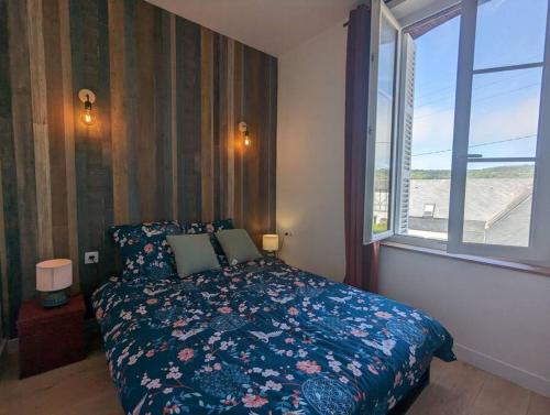 une chambre avec un lit et une grande fenêtre dans l'établissement Appartement aux portes des rues piétonnes, à Fécamp