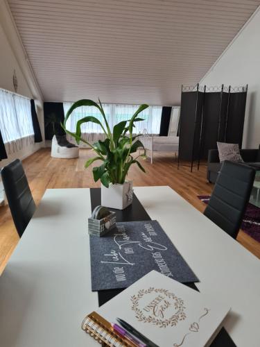 a meeting room with two tables and a plant at Muota River & Industry Apartment by Nature Apartments Switzerland in Muotathal