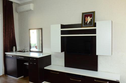 a living room with a tv and a mirror at Cozy Family Cottages in Vǝndam