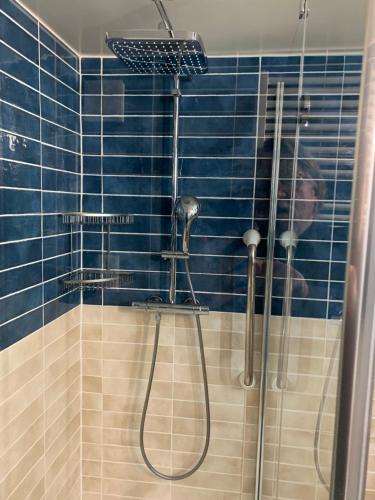 eine blau geflieste Dusche mit einem Mann, der ein Foto macht in der Unterkunft Tournicolette - 52 m2 charme fou in Chardonne