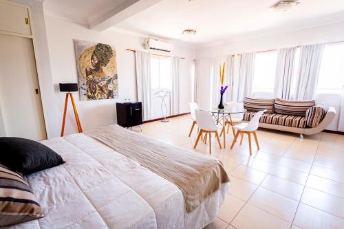 a bedroom with a bed and a table and chairs at Hotel Cuesta de Miranda in Villa Unión