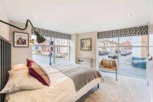 a bedroom with a large bed and a large window at Fulham Townhouse, 2 Baths, Parking, Breakfast in London