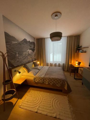 a bedroom with a bed and a painting on the wall at Apartmán Sirius in Štôla