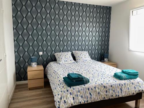 - une chambre avec un lit et des serviettes vertes dans l'établissement La Villa des Amarelles à Pornic - labellisée 3*, à Pornic