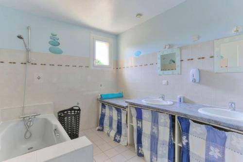 une salle de bain avec deux lavabos et une baignoire dans l'établissement Grand Gite familiale le Clairaiy 1, à Trémeur