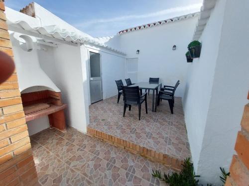 a patio with a table and chairs in a building at CASA JARO in Sierra de Yeguas