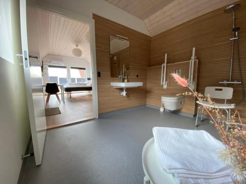 a bathroom with a sink and a toilet in a room at Esehytter Luxury Holiday Home near Beach in Nørre Nebel