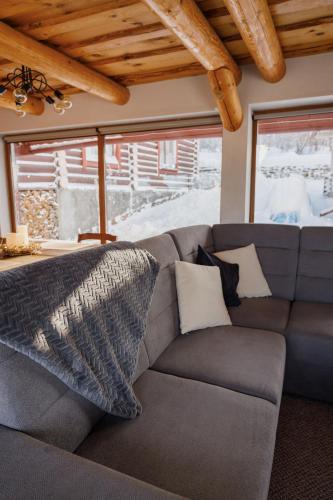 a living room with a gray couch and a window at Hygge House in Vyshka
