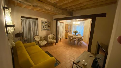een woonkamer met een gele bank en een tafel bij Casa Bartoli - Panoramic House Buggiano Castello in Borgo a Buggiano