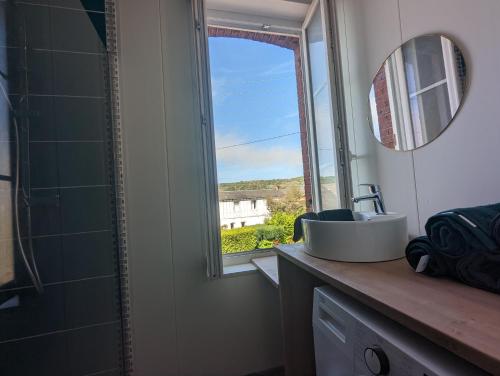 a bathroom with a sink and a window at Appartement aux portes des rues piétonnes in Fécamp