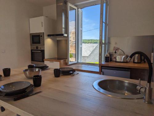 une cuisine avec un évier et une grande fenêtre dans l'établissement Appartement aux portes des rues piétonnes, à Fécamp