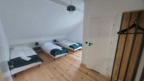 Habitación con 2 camas y pasillo con puerta en Osada Natura Wygranka, en Kłoczew