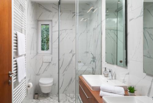 a bathroom with a toilet and a sink and a shower at Villa Roca with heated pool and sauna in Privlaka
