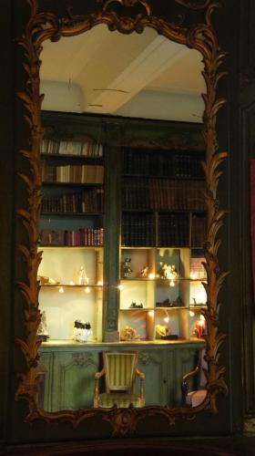 un miroir décoré dans une pièce avec une étagère et des livres dans l'établissement Hôtel particulier Maleteste, à Dijon