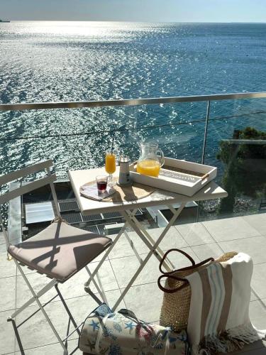 a table and chairs on a balcony with a view of the ocean at Villa_a.mare in Aurisina
