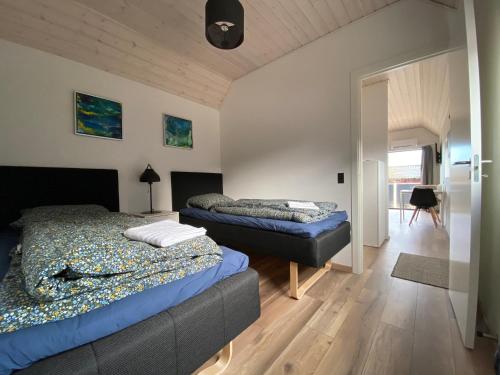 a bedroom with two beds and a hallway with a table at Esehytter Luxury Holiday Home near Beach in Nørre Nebel
