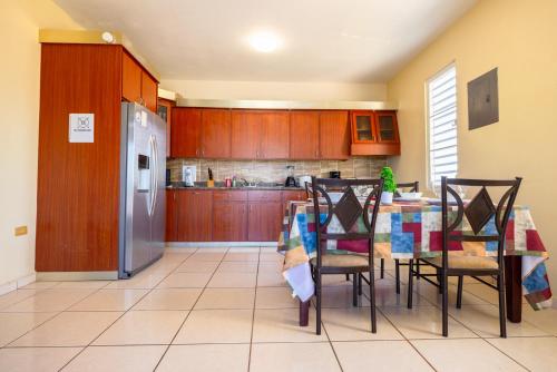 a kitchen with a table with chairs and a refrigerator at Colinas del Atlantico Vacational House 2nd Floor in Isabela