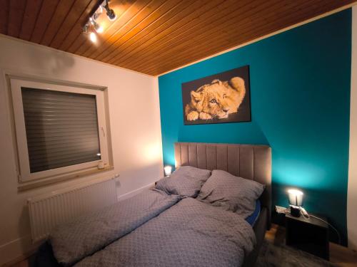 a bedroom with a bed with a lion picture on the wall at Haus am ruhige Lage in Langscheid Nähe sorpesee in Melschede