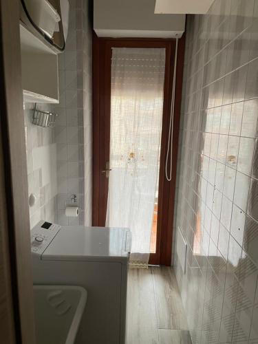 a bathroom with a window and a sink and a toilet at Appartamento da Carmela in Cagliari