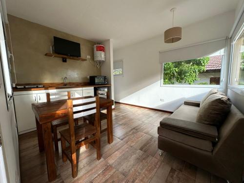 sala de estar con mesa y sofá en La Lomada Villa Gesell en Villa Gesell