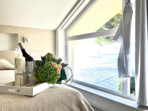 a bedroom with a window with a bottle of wine at Villa_a.mare in Aurisina