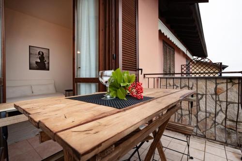una mesa de madera con un jarrón de flores en el balcón en CASA PARIS, en Sale Marasino