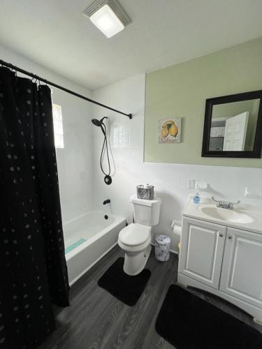 a bathroom with a toilet and a tub and a sink at “La Casita” Beautiful home in the heart of Miami ! in Miami