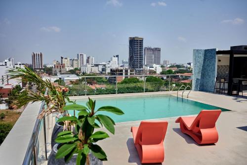 einen Pool mit 2 Stühlen und Stadtblick in der Unterkunft Monoambiente CasArte Takubamba in Santa Cruz de la Sierra