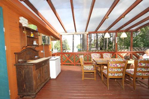 una veranda riparata con tavolo e sedie di Dom nad jeziorem Dadaj BISKUPIEC a Wilimy