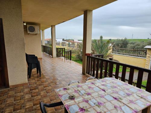 a porch with a table and chairs on a balcony at Casa Alegria in Abertura
