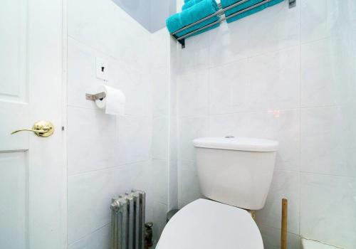 Baño blanco con aseo y radiador en Gorgeous 2 Bedroom apartment in NYC!, en Nueva York