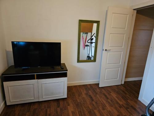 a living room with a flat screen tv on a cabinet at Casa Alegria in Abertura