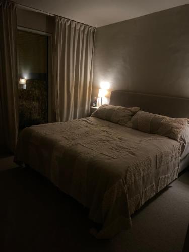 een slaapkamer met een bed met 2 lampen en een raam bij Villa Limhamn in Malmö