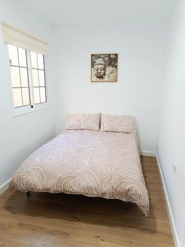 a bed in a white room with a window at Apartamento Meraki in Santa Cruz de Tenerife