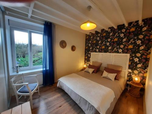 um quarto com uma cama e uma janela em GITE CHEZ BERTHE em Pontfarcy