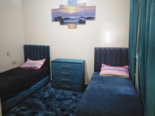 1 dormitorio con 2 camas, vestidor y mesita de noche en Appartement du lux très propre bien équipé au cœur de la ville nouvelle, en Meknès