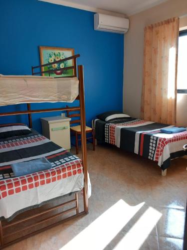 two beds in a room with blue walls at Spacious apartment in Marsalforn, Gozo in Marsalforn