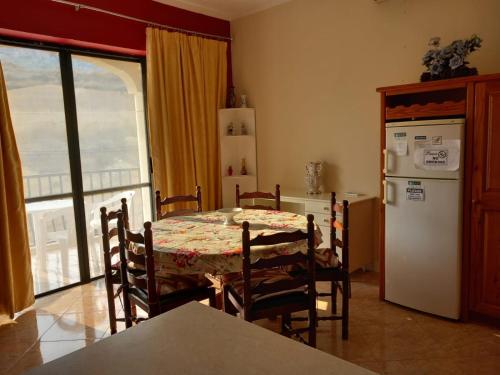 una cucina con tavolo e frigorifero bianco di Spacious apartment in Marsalforn, Gozo a Marsalforn